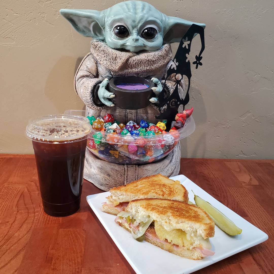 Come in to the Gnoshery, you should! May the 4th be with you all as we roll out our special intergalactic cantina menu! Available all this week, come in and try some of the new fun features we have! Pictured, feel the power of the dark side with an iced Darksaber, or take a gamble on the spicy, (un)savory, and surprisingly sweet "Sando" Calrissian! 

#TheGnoshery #GnomeGamesSturgeonBay #StarWarsDay #MayThe4th #BoardGameCafe #DestinationSturgeonBay